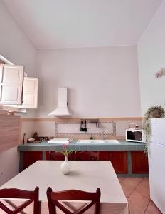 a kitchen with a white table and a white refrigerator at Butera Apartments in Bagheria