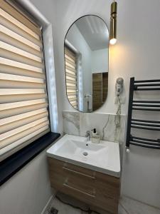 a bathroom with a sink and a mirror at sicanT Apartments - Self Check-in in Constanţa