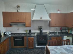 a kitchen with wooden cabinets and a stove top oven at Casa López in San Mamede de Carnota