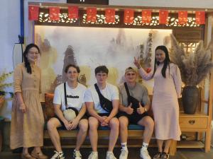 een groep mensen die op een bank zitten bij Xiangxi's Love - Yangyun Hotel in Zhangjiajie