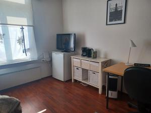una pequeña sala de estar con TV y mesa. en Toimisto-Majoitus A, en Kokkola 1 foto más