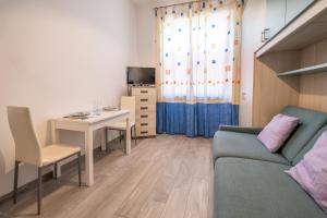 a living room with a couch and a table and a desk at Casa Olga in San Bartolomeo al Mare