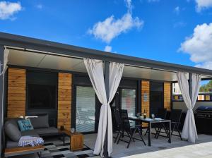 a patio with curtains and a couch and a table at Mobile home Marina in Drage