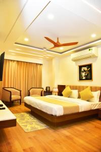 a bedroom with a large bed and a ceiling fan at Hotel Divine Peak in Pachmarhī