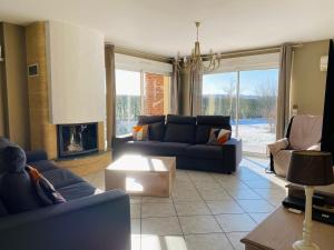 a living room with blue couches and a fireplace at Chez Lucie et Compagnie pavillon familial avec beau jardin in Vron