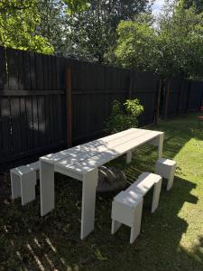 un tavolo da picnic bianco e panche in un cortile di Design apartments Jūrmāja a Ainaži