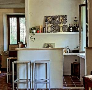 una cocina con una barra con dos taburetes en Villa Amai, en Lequio Tanaro