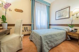 sypialnia z łóżkiem, biurkiem i krzesłem w obiekcie Hotel Michelangelo w Sorrento