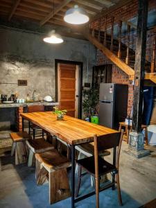 パンタイチェナンにあるRumah Wan Villa with Swimming Poolのキッチン(木製テーブル、椅子、冷蔵庫付)