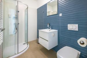 ein Bad mit einem WC, einem Waschbecken und einer Dusche in der Unterkunft Anchor Apartman by HelloBalatonlelle in Balatonlelle