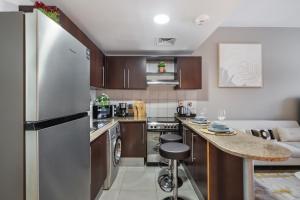 een keuken met een koelkast en een aanrechtblad bij Furnished Studio In Arch Tower, Jlt Near Metro in Dubai +14 foto's