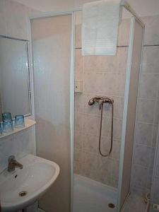 y baño con ducha y lavamanos. en PSZ Hotel Beach Földvár en Balatonföldvár