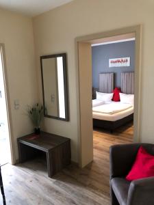 a living room with a bed and a mirror at Hotel Rahserhof in Viersen