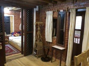 a room with a brick wall with a tower in it at Yamba Traditional Home in Pātan