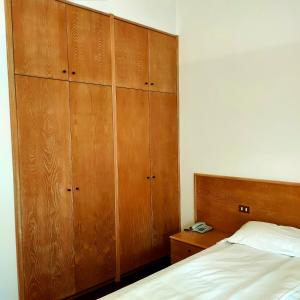 1 dormitorio con 1 cama y armarios de madera en Hotel Del Parco Ristorante Loris, en Pieve di Soligo