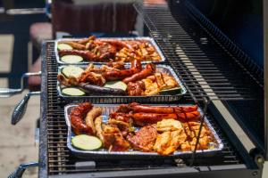 a grill with several trays of food on it at GORSKI RESORT Lux Apartments Jacuzzi & Sauna in Poronin