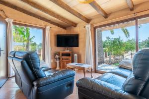 een woonkamer met 2 lederen stoelen en een flatscreen-tv bij Capricho in Portocolom