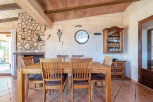 een eetkamer met een houten tafel en stoelen bij Capricho in Portocolom