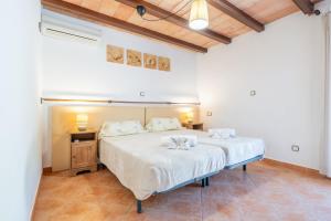 een slaapkamer met een groot bed met witte lakens bij Capricho in Portocolom +24 foto's