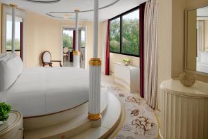 a bedroom with a bed and a tub and windows at InterContinental Al Jubail Resort in Al Jubail