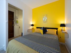 ヴィルールバンヌにあるLE DEDIEU - HYPERCENTRE GARAGE GRATUIT WiFi NETFLIX AMAZON PRIMEのベッドルーム1室(黄色い壁のベッド1台付)