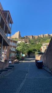een geplaveide straat in een stad met gebouwen bij Old Tbilisi-Albi-Sali in Tbilisi City