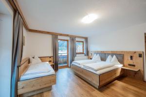 a bedroom with two beds and a large window at Karlingerhof in Achenkirch
