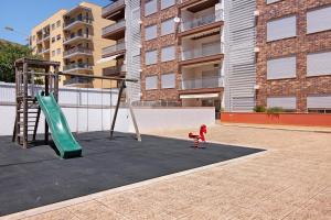Un niño está jugando en un columpio en un parque infantil. en Apartamento Armação de Pêra, en Armação de Pêra