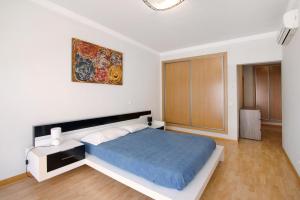 Un dormitorio con una cama y un cuadro en la pared. en Apartamento Armação de Pêra, en Armação de Pêra 18 fotos más