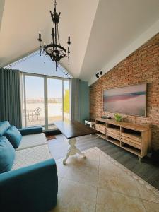 a living room with a brick wall and a tv at HOME by FLATTO APARTMENT in Ho Chi Minh City