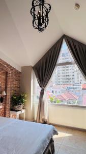 a bedroom with a bed and a large window at HOME by FLATTO APARTMENT in Ho Chi Minh City