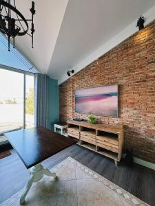 a living room with a brick wall with a television at HOME by FLATTO APARTMENT in Ho Chi Minh City