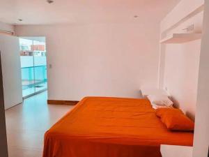 a bedroom with an orange bed in a white room at CA1 - Casa completa con Piscina e hidromasajes in Lurín +4 photos