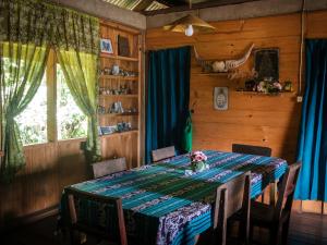 ein Esszimmer mit einem Tisch mit Stühlen und einem Fenster in der Unterkunft Ne Pakku Manja Family Home in Rantepao