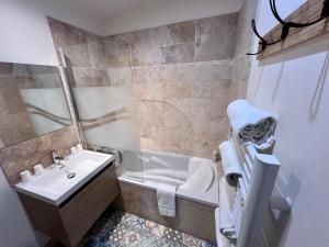 a bathroom with a sink and a toilet and a tub at Hotel Majestic in N&icirc;mes