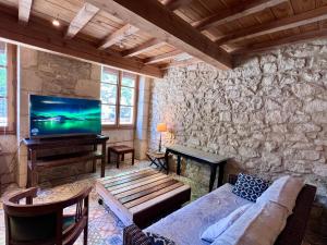 a living room with a couch and a flat screen tv at Hotel Majestic in Nîmes