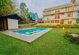 a swimming pool in a yard next to a building at Glen Castle Vagamon Pool Resort by VOYE HOMES in Vagamon