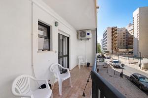 un balcone con 2 sedie bianche e una finestra di Seaside Sanctuary - Praia da Rocha a Portimão