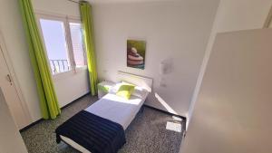 a small bedroom with a bed and a window at Apartament Santa Margarida in Roses