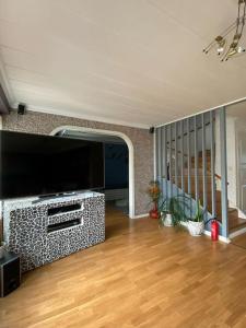 a living room with a television and a wooden floor at Kalmar - Bergavik in Kalmar