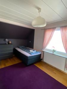 a bedroom with a bed and a purple rug at Kalmar - Bergavik in Kalmar