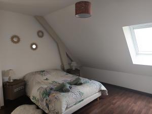 Dormitorio pequeño con cama en el ático en Le gîte de la source, en Cailly