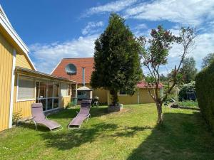 a yard with two lounge chairs and a house at Kalmar - Bergavik in Kalmar