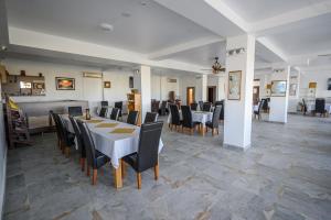 a dining room with a white table and black chairs at Hotel Austin Ov in Ovidiu