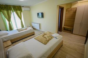 a hotel room with two beds and a window at Hotel Austin Ov in Ovidiu +34 photos