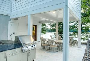 een buitenkeuken met een grill en een patio bij Lakemore Resort - New Luxury Lakefront Brown House in Kingsley
