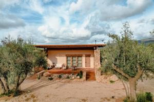 a house in the desert with trees in front of it at Hábimo - Valle de Guadalupe in Valle de Guadalupe