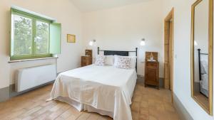 a bedroom with a white bed and a window at VILLA A CASA DI GIOVANNI 12, Emma Villas in Acquapendente +34 photos