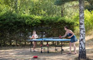 LanobreHuttopia Lac de la Siauve的一名妇女和一名男孩在桌上打乒乓球