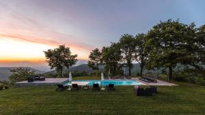 a swimming pool in a field with a sunset in the background at VILLA A CASA DI GIOVANNI 12, Emma Villas in Acquapendente